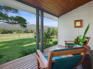 a porch with chairs and a view of a field at Meerea Country Estate adjoining Wollombi National Park in Bulga