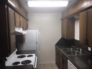 a kitchen with a white refrigerator and wooden cabinets at One bedroom close to Fort Sill! in Lawton
