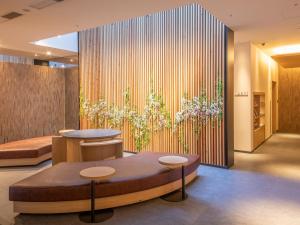 un vestíbulo con dos mesas y un muro de flores en Hotel Keihan Kyoto Ekiminami, en Kioto