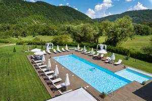 an outdoor swimming pool with chairs and umbrellas at Family Hotel Strannopriemnitza in Oreshak