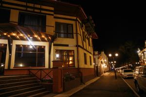 a building with lights on a street at night at Hotel Na starom meste in Biysk