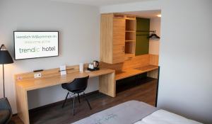 a room with a bed and a desk at trendic hotel in Marktoberdorf