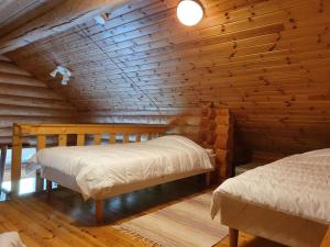 a bedroom with two beds in a log cabin at Pitkämö Canyon Camping Oy in Kurikka