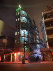 un edificio alto con una cruz encima por la noche en Khách sạn Hoa Anh Anh en Ho Chi Minh