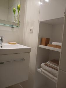 a white bathroom with a sink and a mirror at La Maison de Madame Baudy in Giverny