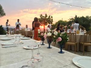 a group of people standing around a table with flowers at PYRGOS RALLI ESTATE Guesthouse in Egina