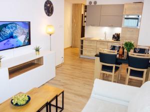 a living room with a kitchen and a dining room at Sun4You Polanki Park in Kołobrzeg