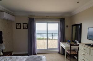 a bedroom with a bed and a window with a view at Marilyn Boutique Hotel in Durban