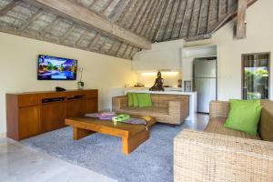 a living room with two couches and a tv at Serene Villas in Seminyak