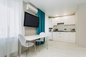 a kitchen with a white table and chairs and a tv at Apart-hotel I. Sirko New Building 2 floor in Sumy