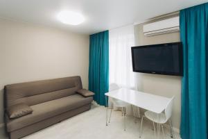 a living room with a couch and a table and a tv at Apart-hotel I. Sirko New Building 2 floor in Sumy