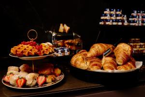a buffet with three plates of pastries and croissants at Hotel Estheréa in Amsterdam