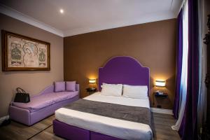 een slaapkamer met een paars bed en een bank bij JB Relais in Rome