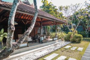 a house with a pavilion in a garden at The Cakra Hotel in Denpasar