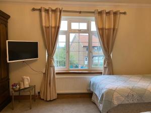 1 dormitorio con cama y ventana en Thompsons Arms, en Flaxton