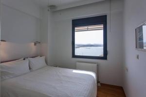 a bedroom with a white bed and a window at Sea & Town Getaway in Chania