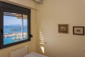 a bedroom with a window with a view of the ocean at Sea & Town Getaway in Chania