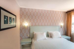 a bedroom with a white bed with two pillows at Florida Park Hotel, Florida Road in Durban