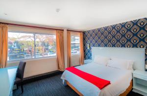 a bedroom with a bed and a desk and a window at Florida Park Hotel, Florida Road in Durban
