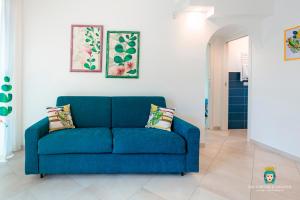 un sofá azul sentado en una sala de estar en Chi nnicchi e nnacchi - Luxury apartments, en Milazzo