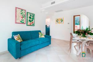uma sala de estar com um sofá azul e uma mesa em Chi nnicchi e nnacchi - Luxury apartments em Milazzo
