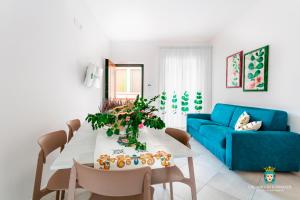 sala de estar con mesa y sofá azul en Chi nnicchi e nnacchi - Luxury apartments, en Milazzo