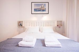 1 dormitorio con 1 cama con sábanas y almohadas blancas en Esparteros FreshApartments by Bossh! Apartments, en Málaga
