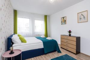 niewielka sypialnia z łóżkiem i komodą w obiekcie Sleepway Apartments - Garbary 95-112a w Poznaniu