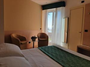 a room with a bed, chair, and a window at Hotel Esperia in Genoa