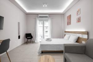 biała sypialnia z łóżkiem i kanapą w obiekcie Lausanne, Nilie Hospitality MGMT w Salonikach