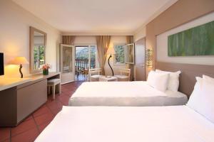 a hotel room with two beds and a desk at Hapimag Sea Garden Resort in Yaliciftlik +54 photos