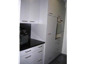 a kitchen with white cabinets and a stove top oven at Gelgia Sommer-Salis in Bivio