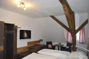 a bedroom with two beds and a table and chairs at Gasthof Pension Zum goldenen Hirschen in Burgbernheim