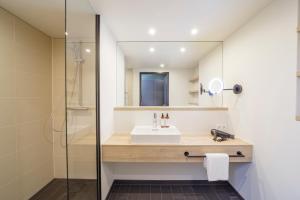 a bathroom with a sink and a mirror at Black F House - Serviced Apartments in Freiburg im Breisgau