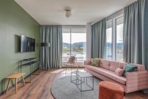 a living room with a pink couch and a large window at Black F House - Serviced Apartments in Freiburg im Breisgau
