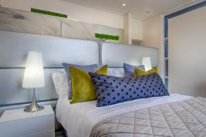 a bedroom with a bed with yellow and blue pillows at Badgemore Villa Guesthouse in Cape Town