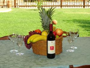 拉戈堡的住宿－拉凱奧利農莊鄉村民宿，一张桌子上摆放着一瓶葡萄酒,还有一篮水果
