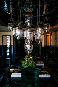 a dining room with a table with chandeliers at Monsieur George Hotel & Spa - Champs-Elysées in Paris