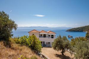 a house on a hill with a view of the water at Kalithea Studios in Stafylos