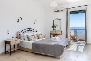 a bedroom with a bed with a view of the ocean at Kalithea Studios in Stafylos