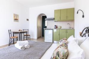 a living room with a couch and a kitchen at Kalithea Studios in Stafylos