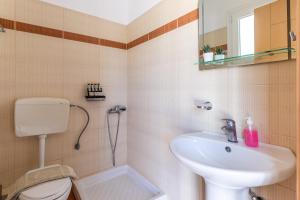 a bathroom with a toilet and a sink at Kalithea Studios in Stafylos