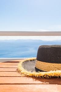 un chapeau en paille assis sur un quai à côté de l'océan dans l'établissement Kalithea Studios, à Stafylos