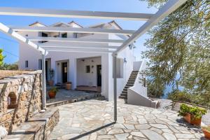 a white house with a stone walkway and stairs at Kalithea Studios in Stafylos