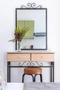 a mirror over a desk with a vase of flowers at Kalithea Studios in Stafylos