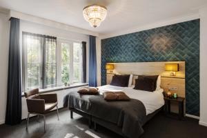 a bedroom with a large bed and a chandelier at Hotel Restaurant De Wolfsberg in Groesbeek
