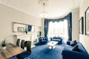 a living room with blue furniture and a table at Argyll Apartments in Glasgow