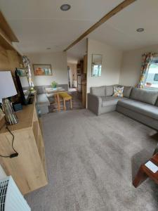 een woonkamer met een bank en een tafel bij Rustling Pines at Knaresborough Lido in Harrogate