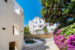 a white building with pink flowers in front of it at Beco do Paiol 28 by Destination Algarve in Lagos