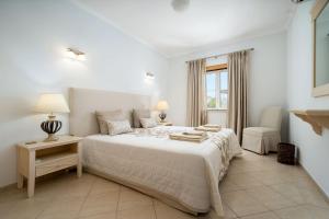 a white bedroom with a large bed and a window at Beco do Paiol 28 by Destination Algarve in Lagos